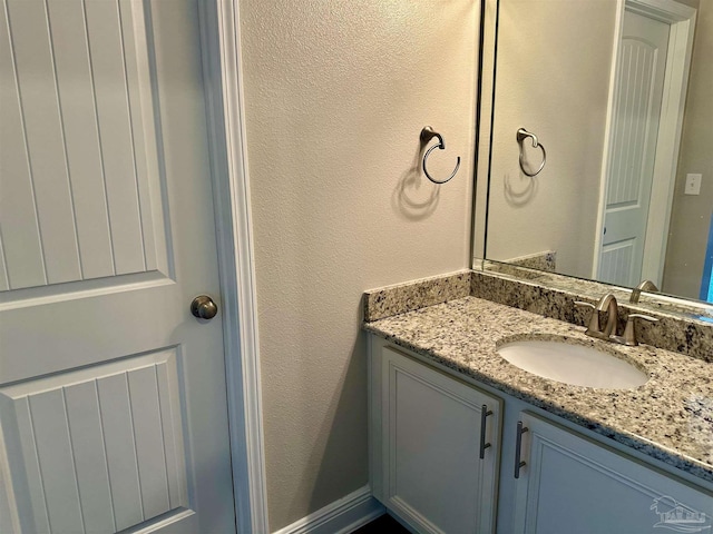 bathroom featuring a textured wall and vanity