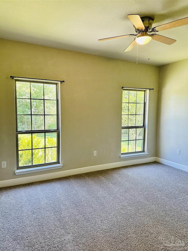 unfurnished room featuring baseboards, carpet flooring, and a ceiling fan