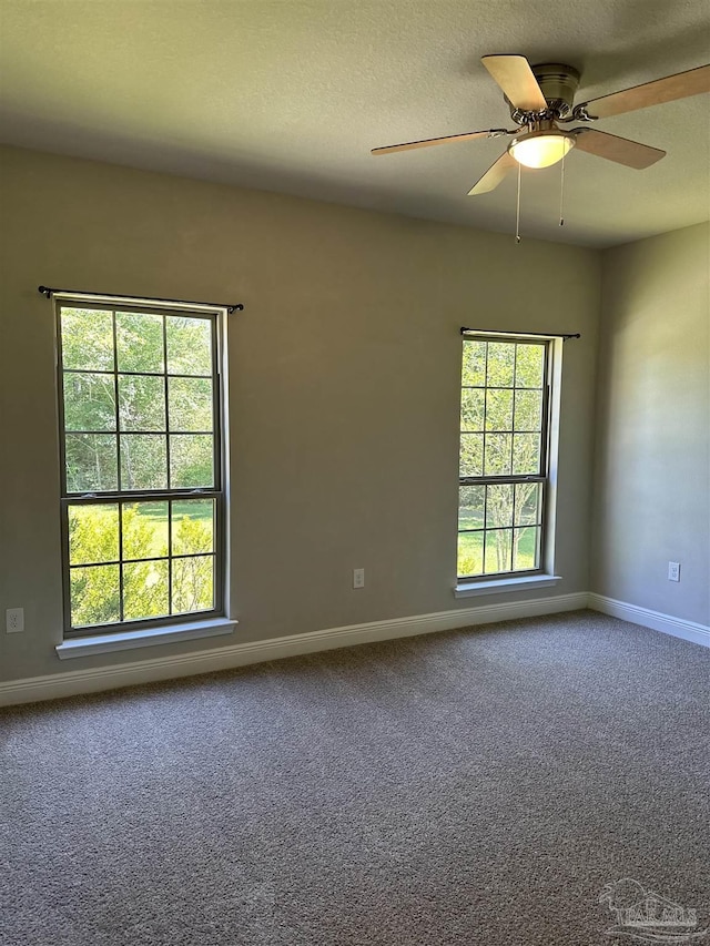 carpeted empty room with baseboards and ceiling fan