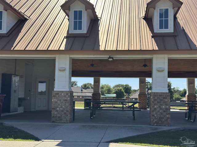 exterior space with a gazebo, metal roof, stone siding, and a standing seam roof