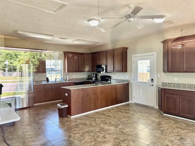 kitchen featuring a sink, black microwave, light countertops, a ceiling fan, and range with electric cooktop