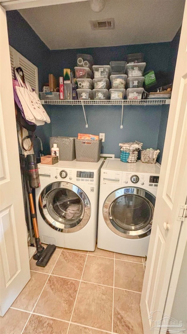 washroom with tile patterned floors and washing machine and clothes dryer