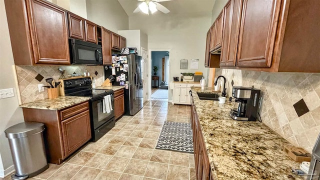 kitchen with ceiling fan, sink, light stone countertops, tasteful backsplash, and black appliances