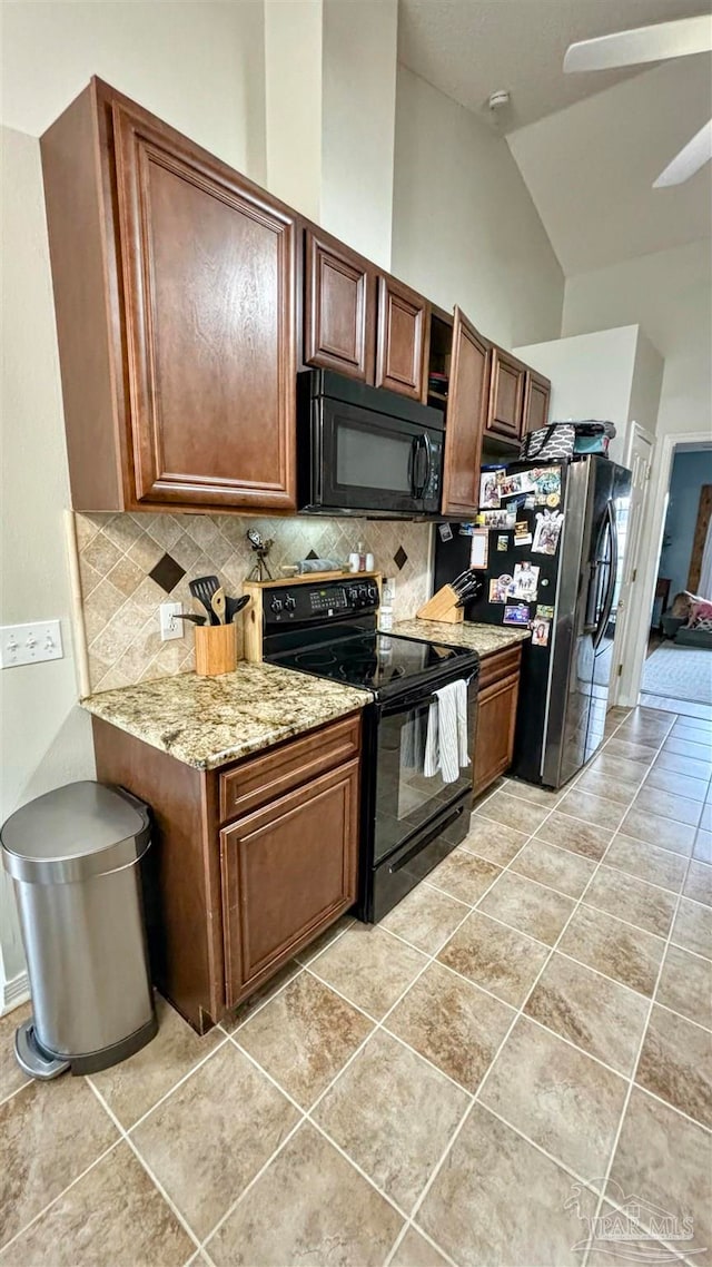 kitchen featuring black appliances, vaulted ceiling, backsplash, and light tile patterned floors