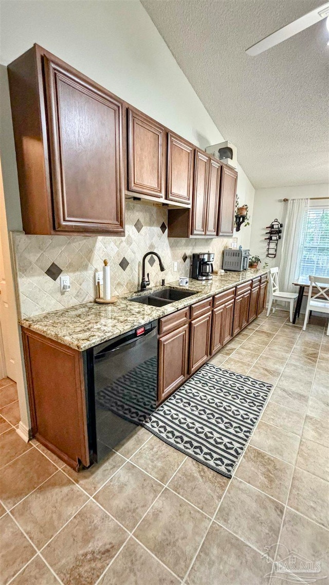 kitchen with sink, light tile patterned flooring, lofted ceiling, a textured ceiling, and dishwasher