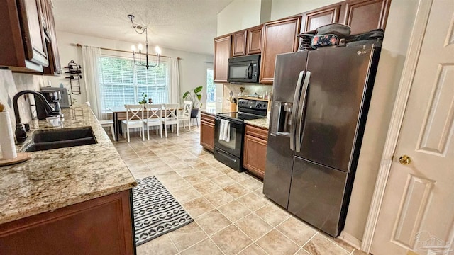 kitchen featuring a textured ceiling, sink, black appliances, decorative light fixtures, and a chandelier