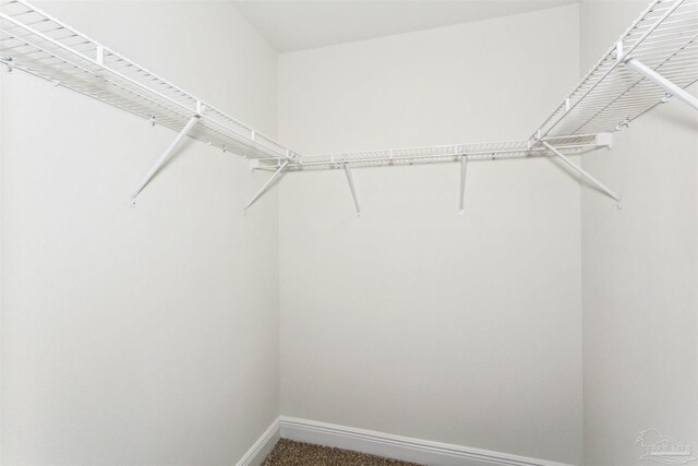 unfurnished living room featuring ceiling fan with notable chandelier, light colored carpet, sink, and a tray ceiling