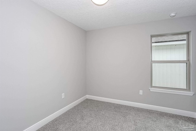 carpeted empty room featuring a textured ceiling