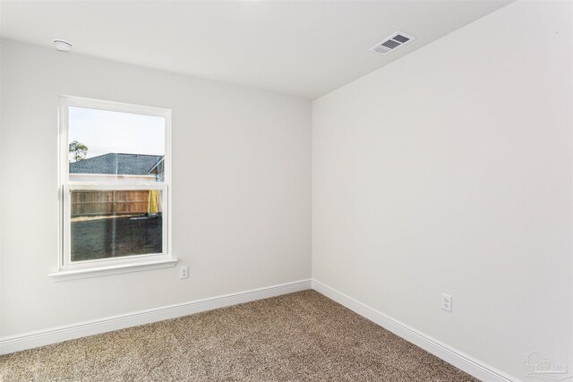 spare room with a textured ceiling, ceiling fan, a raised ceiling, and light colored carpet