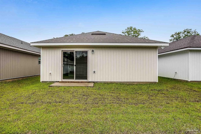 rear view of house featuring a lawn