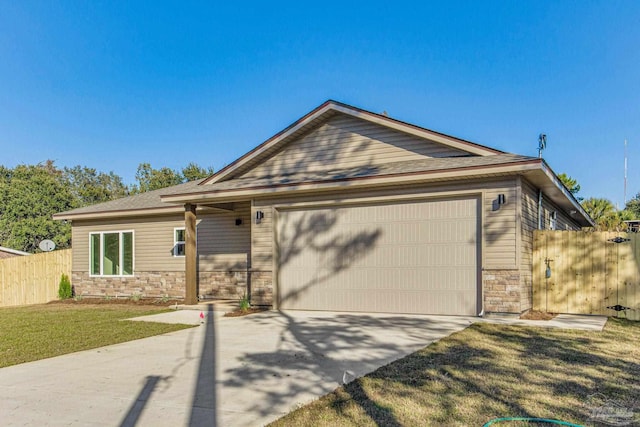 view of front facade with stone siding, fence, driveway, and an attached garage