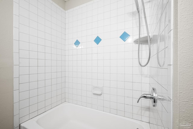 full bath with shower / bathtub combination and a textured wall