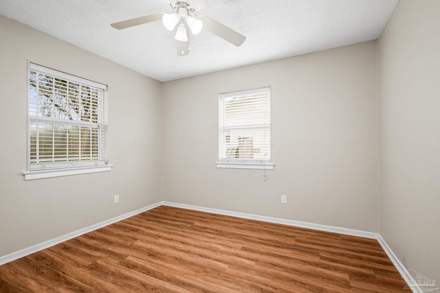 empty room featuring ceiling fan, a textured ceiling, wood finished floors, and baseboards