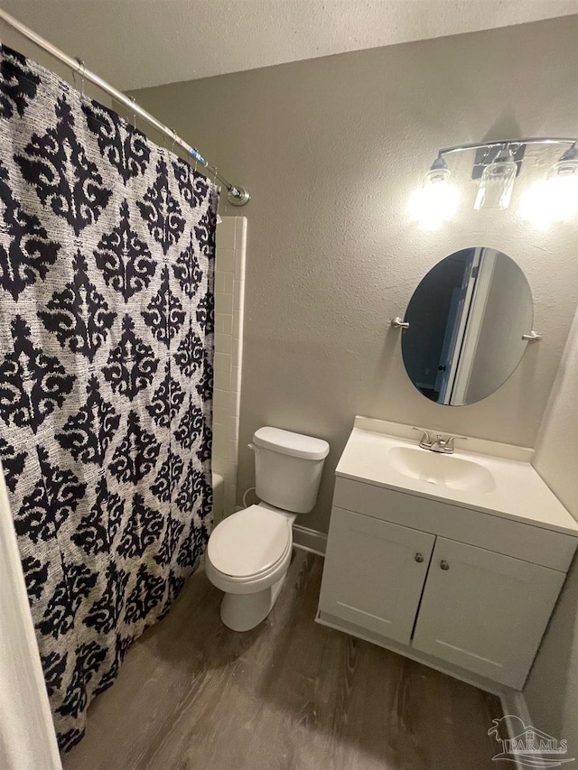 full bathroom with vanity, shower / bath combo, hardwood / wood-style flooring, toilet, and a textured ceiling