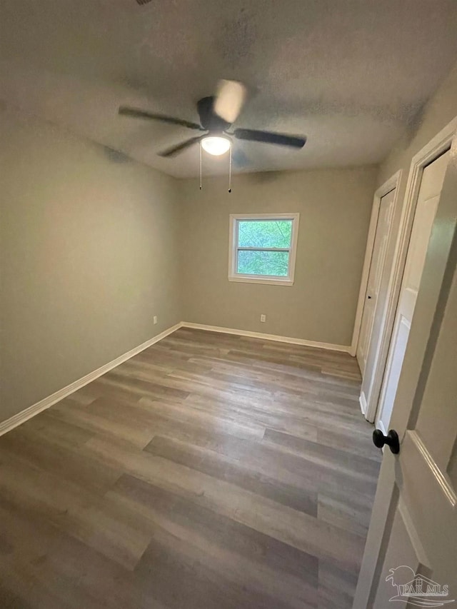 unfurnished bedroom featuring ceiling fan, hardwood / wood-style floors, and a textured ceiling