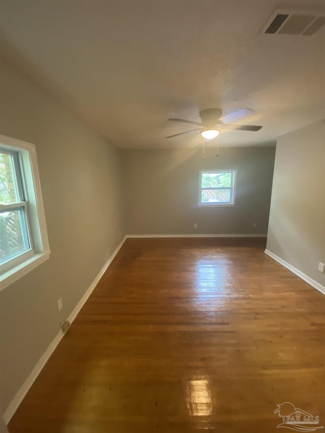 spare room featuring plenty of natural light, ceiling fan, and wood-type flooring