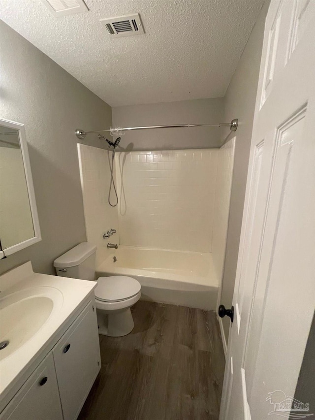 full bathroom with hardwood / wood-style flooring, vanity, toilet, and a textured ceiling