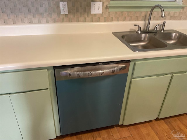 kitchen featuring light wood-type flooring, stainless steel dishwasher, green cabinets, and sink