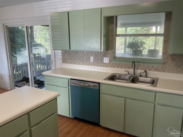 kitchen featuring hardwood / wood-style floors, stainless steel dishwasher, green cabinetry, and sink