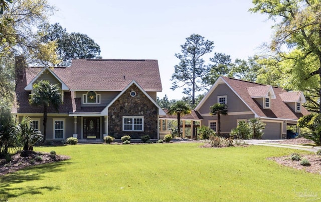 view of front of property featuring a garage, a front yard, and stone siding