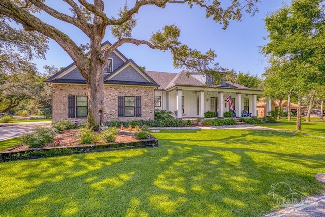 view of front facade with a front lawn, a porch, and brick siding