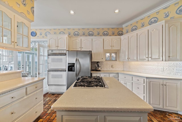 4757 Chinquapin Dr, Gulf Breeze, FL 32563 - kitchen featuring stainless steel appliances, white cabinetry, light countertops, decorative backsplash, and a center island