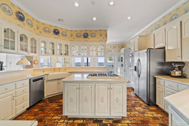 4757 Chinquapin Dr, Gulf Breeze, FL 32563 - kitchen featuring appliances with stainless steel finishes, brick floors, a sink, a kitchen island, and glass insert cabinets