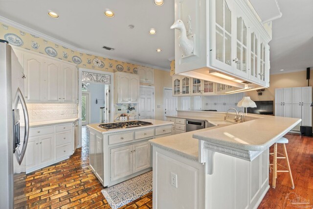 4757 Chinquapin Dr, Gulf Breeze, FL 32563 - kitchen with ornamental molding, stainless steel appliances, a sink, a kitchen island, and decorative backsplash