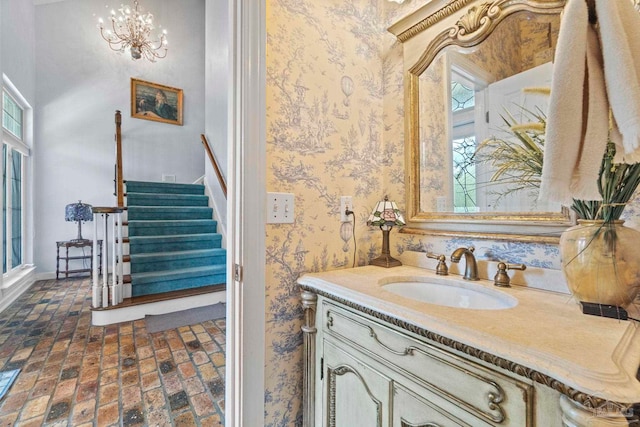 4757 Chinquapin Dr, Gulf Breeze, FL 32563 - bathroom with brick flooring, wallpapered walls, vanity, a chandelier, and baseboards