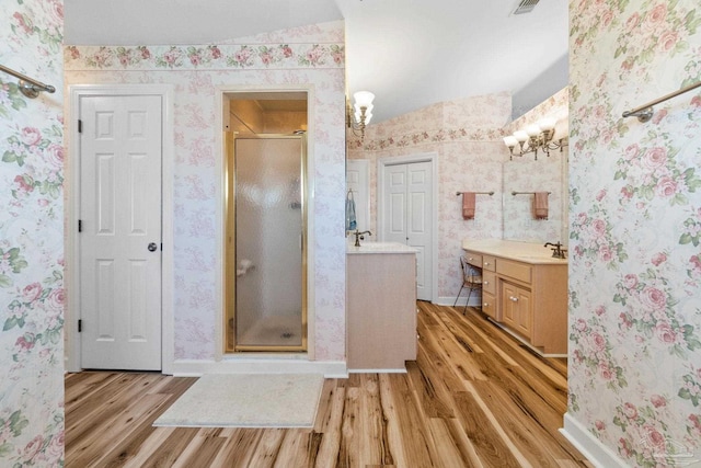 4757 Chinquapin Dr, Gulf Breeze, FL 32563 - full bath with wood finished floors, a stall shower, two vanities, wallpapered walls, and baseboards
