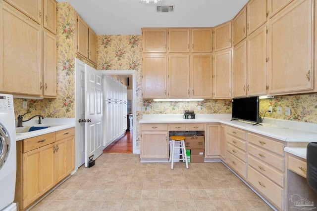 4757 Chinquapin Dr, Gulf Breeze, FL 32563 - kitchen featuring wallpapered walls, light brown cabinets, light countertops, washer / clothes dryer, and a sink
