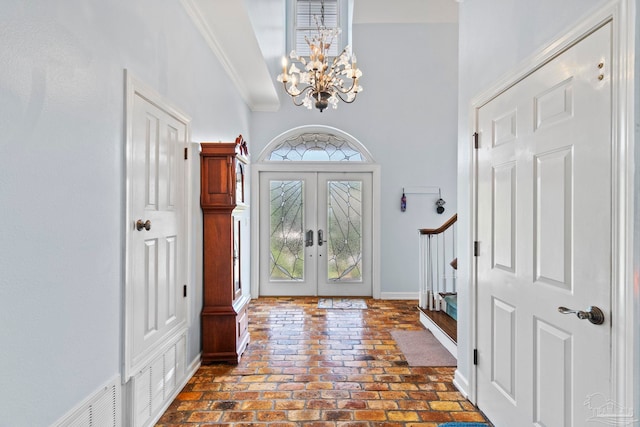 4757 Chinquapin Dr, Gulf Breeze, FL 32563 - foyer with a chandelier, french doors, brick flooring, a towering ceiling, and ornamental molding