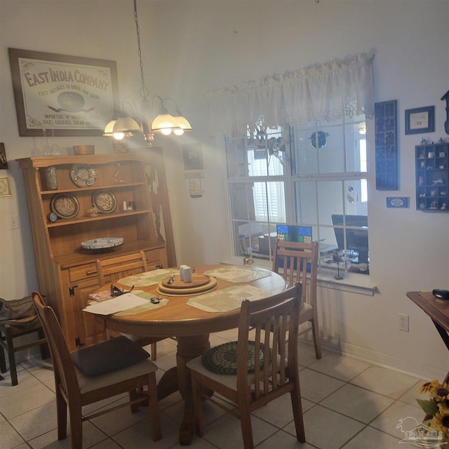 dining room with light tile patterned floors and a notable chandelier