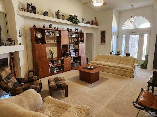 living room featuring a towering ceiling and light colored carpet