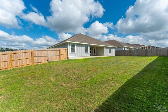 rear view of property with a yard