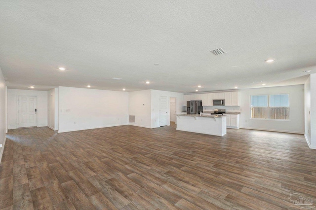 unfurnished living room featuring hardwood / wood-style floors and a textured ceiling