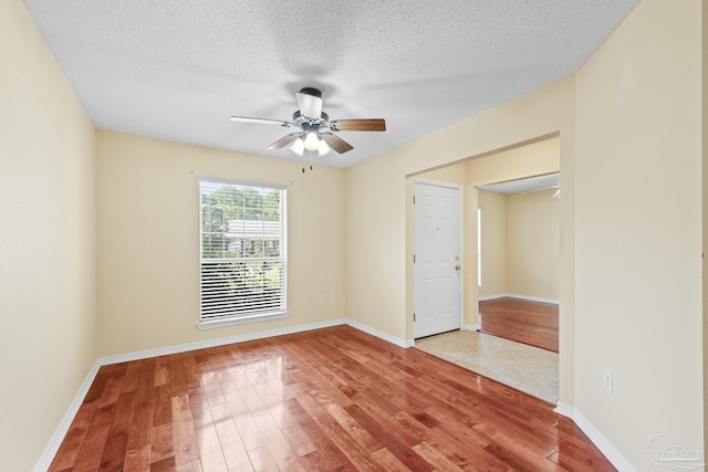 2121 Middleton Dr, Navarre, FL 32566 - unfurnished room featuring baseboards, a ceiling fan, a textured ceiling, and wood finished floors