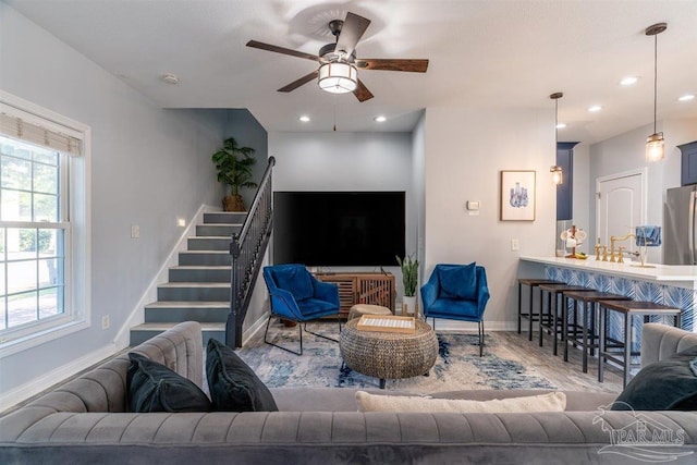 living room with recessed lighting, ceiling fan, stairway, and baseboards