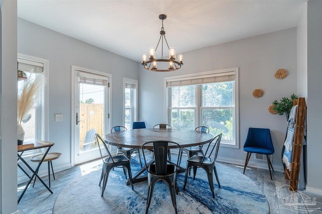 dining area featuring a chandelier and baseboards