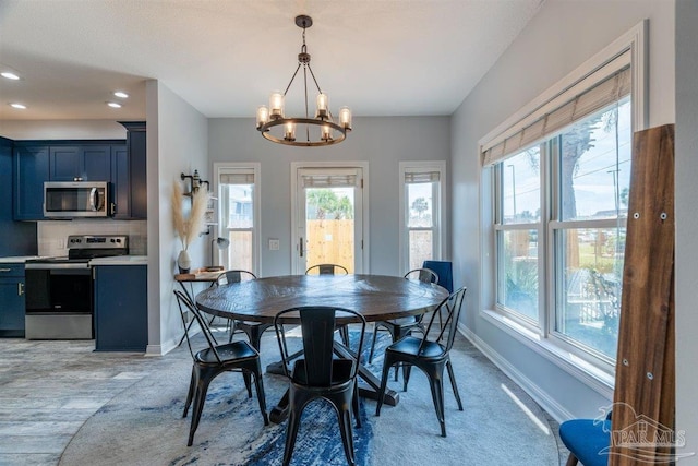 dining space with a notable chandelier and light wood-type flooring