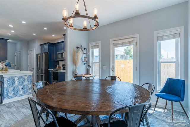 dining area with a chandelier, light wood-type flooring, and recessed lighting