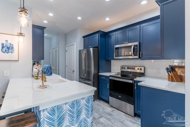 kitchen with hanging light fixtures, blue cabinetry, a peninsula, and stainless steel appliances