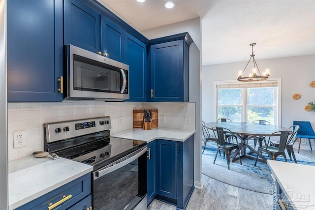 kitchen featuring tasteful backsplash, appliances with stainless steel finishes, light wood-type flooring, and blue cabinets