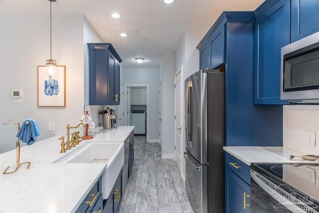 kitchen featuring light hardwood / wood-style flooring, backsplash, hanging light fixtures, light stone counters, and stainless steel appliances