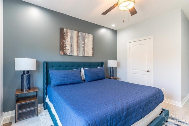 bedroom with light wood-style flooring, baseboards, and a ceiling fan