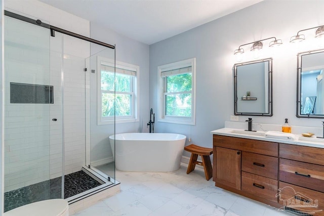 bathroom with marble finish floor, a freestanding bath, vanity, and a shower stall