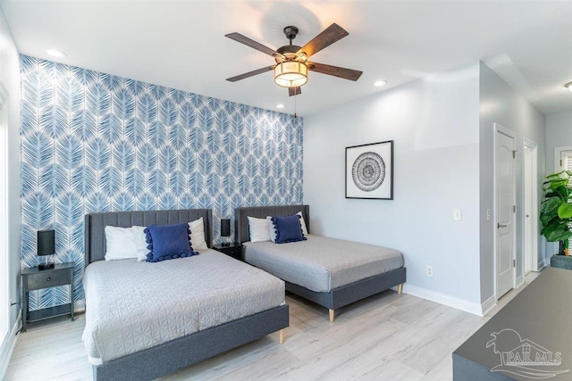 bedroom featuring recessed lighting, an accent wall, a ceiling fan, baseboards, and light wood-style floors