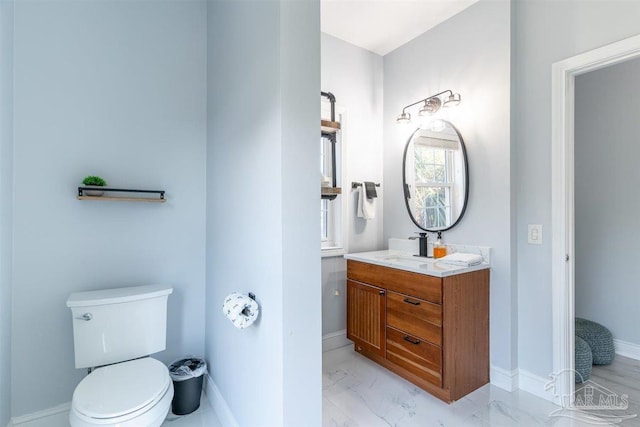 bathroom with marble finish floor, baseboards, vanity, and toilet