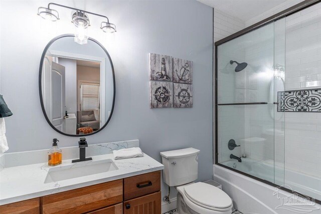 full bath featuring enclosed tub / shower combo, vanity, and toilet