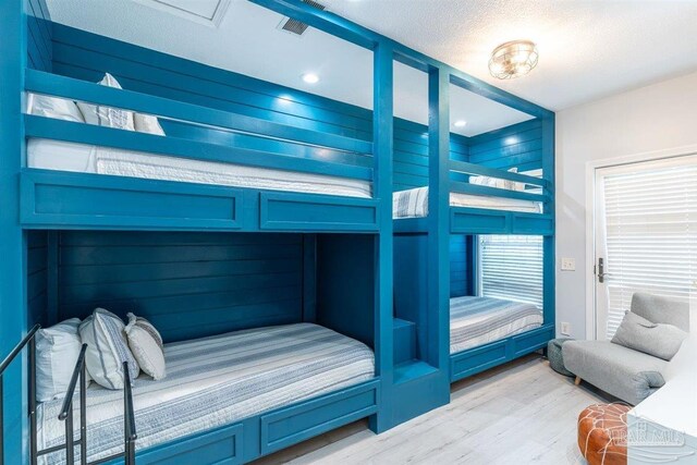 bedroom featuring light wood-type flooring and wood walls